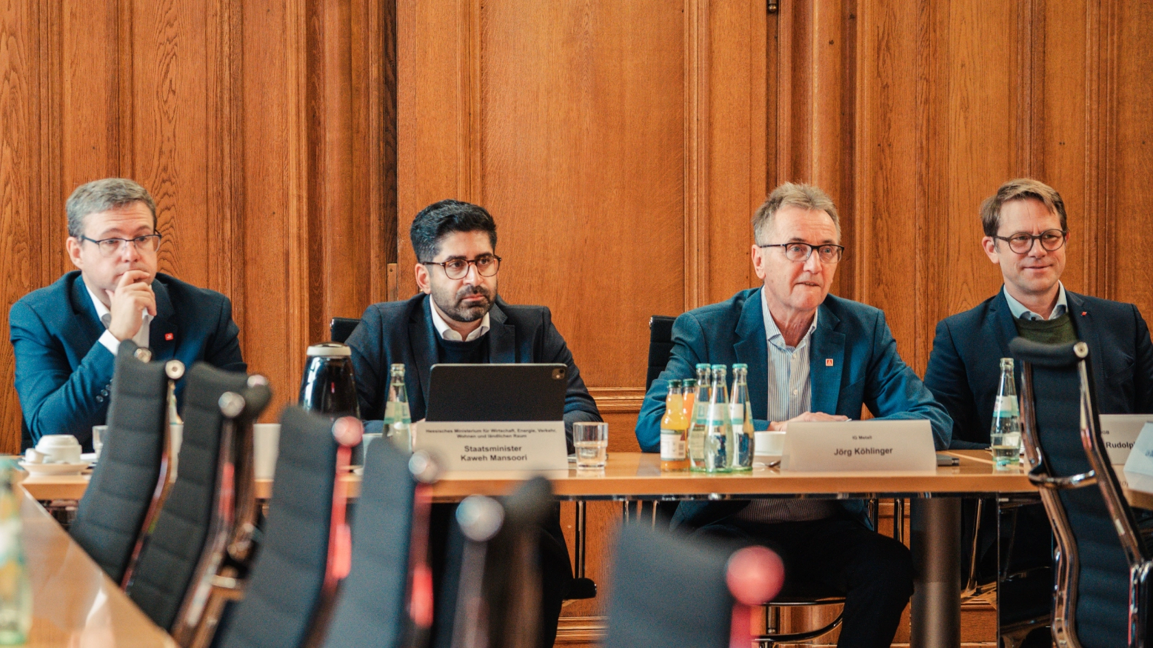 Jörg Köhlinger und andere Geweerkschafter sitzen mit Mansoori auf dem Podium